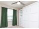 Bedroom featuring natural lighting, a ceiling fan, a window with lush green curtains, and a built-in white closet at 5916 Tulip Flower Dr, Riverview, FL 33578