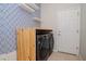 Laundry room featuring modern washer and dryer with wood countertop and decorative accent wall at 5916 Tulip Flower Dr, Riverview, FL 33578