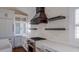 Modern kitchen with stainless steel appliances, custom range hood, and white cabinets at 608 Grove N St, St Petersburg, FL 33701