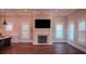 Open-concept living room featuring a fireplace, large television, plantation shutters, and hardwood flooring at 608 Grove N St, St Petersburg, FL 33701
