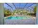 A stunning screened-in pool with pristine water and a house and palm trees in the background at 608 Grove N St, St Petersburg, FL 33701
