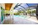 A beautiful in-ground pool and spa are enclosed with a screen, travertine tile, and a covered patio at 608 Grove N St, St Petersburg, FL 33701