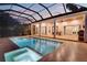 A beautiful in-ground pool and spa with a screen enclosure, travertine tile and a built-in grill at 608 Grove N St, St Petersburg, FL 33701