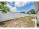 Spacious backyard with a tall white fence and a small area for a garden at 6908 Mesa Verde St, Port Richey, FL 34668