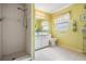Clean bathroom with tiled shower, vanity with ample storage, and a bright window at 6908 Mesa Verde St, Port Richey, FL 34668