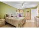 Tranquil bedroom with a ceiling fan, light wood floors, and a cozy reading chair at 6908 Mesa Verde St, Port Richey, FL 34668