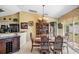 Dining room with a large wood table, elegant chandelier, and access to the kitchen at 6908 Mesa Verde St, Port Richey, FL 34668