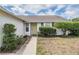Close up of front exterior with a charming yellow front door and well maintained landscaping at 6908 Mesa Verde St, Port Richey, FL 34668