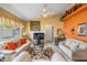 Relaxing living area with a ceiling fan, sofas with throw pillows, and a decorative orange accent wall at 6908 Mesa Verde St, Port Richey, FL 34668