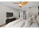 Comfortable bedroom featuring modern ceiling fan, tv, and ensuite bathroom with laundry at 701 S Madison Ave # 505, Clearwater, FL 33756