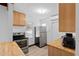 Bright kitchen with stainless steel appliances, wood cabinets, and vinyl flooring at 703/709 Patterson St, Clearwater, FL 33756