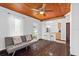 Inviting living room featuring wood-paneled ceiling, ceiling fan, hardwood floors and bar seating to the kitchen at 703/709 Patterson St, Clearwater, FL 33756