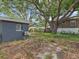Overgrown backyard featuring an exterior view of the home and an A/C unit at 705 3Rd Ne Ave, Largo, FL 33770