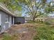 Overgrown backyard with an exterior view of the house, a hose, and other yard equipment at 705 3Rd Ne Ave, Largo, FL 33770
