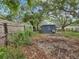 View of the overgrown backyard with a partial view of the home's exterior at 705 3Rd Ne Ave, Largo, FL 33770