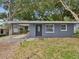 Charming single story home with gray exterior, front carport and mature trees at 705 3Rd Ne Ave, Largo, FL 33770