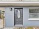 Close up of gray home exterior with ornate front door and a window on either side at 705 3Rd Ne Ave, Largo, FL 33770