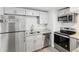 Modern kitchen featuring stainless steel appliances, granite counters, light gray cabinets and gray flooring at 705 3Rd Ne Ave, Largo, FL 33770