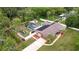 Aerial view showcases a home with pool, solar panels, and fenced yard at 807 E Chapman Rd, Lutz, FL 33549