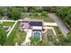 Aerial view features solar panels, screened pool, playground, and mature landscaping at 807 E Chapman Rd, Lutz, FL 33549