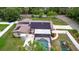 A full home aerial view, highlighting the solar panels, the screened pool, and playground at 807 E Chapman Rd, Lutz, FL 33549