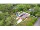 Aerial view showcasing a home with a large yard, screened pool, and solar panels at 807 E Chapman Rd, Lutz, FL 33549