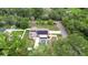 An aerial view shows the home with a solar panel roof, a pool, and a surrounding yard with green trees at 807 E Chapman Rd, Lutz, FL 33549