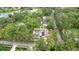 Aerial view of a property with a pool, lush greenery, and mature trees at 807 E Chapman Rd, Lutz, FL 33549
