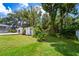 Landscaped backyard with a storage shed provides ample space for gardening and outdoor activities near pool area at 807 E Chapman Rd, Lutz, FL 33549