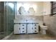 Well-lit bathroom with double vanity, tiled shower, and toilet at 807 E Chapman Rd, Lutz, FL 33549