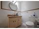 Bathroom featuring a vanity with a neutral countertop and round mirror, and a toilet with tiled walls at 807 E Chapman Rd, Lutz, FL 33549