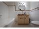 Well-lit bathroom with vanity, large round mirror, classic white tile, and combo tub/shower at 807 E Chapman Rd, Lutz, FL 33549