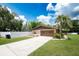 This is a well-maintained home with a two-car garage, lush green grass, landscaping, and a white fence at 807 E Chapman Rd, Lutz, FL 33549