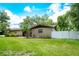 This eye-level exterior shot shows a charming ranch-style home with a well-maintained front yard and white fence at 807 E Chapman Rd, Lutz, FL 33549