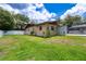 Exterior view of the home highlighting the spacious yard and the screened-in pool area, perfect for outdoor living at 807 E Chapman Rd, Lutz, FL 33549