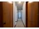 Hallway with multiple doors, offering access to different rooms, and light tile flooring at 807 E Chapman Rd, Lutz, FL 33549