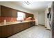 Traditional kitchen with wood cabinets, tile backsplash, and tile floors, providing functionality and style at 807 E Chapman Rd, Lutz, FL 33549