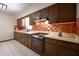 Traditional kitchen featuring wood cabinets, classic appliances, and white tile flooring at 807 E Chapman Rd, Lutz, FL 33549
