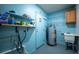 Bright utility room with shelving, sink, and water heater at 807 E Chapman Rd, Lutz, FL 33549