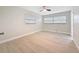 Comfortable bedroom featuring light wood-look floors, neutral paint, and bright natural light at 8375 Burgundy N Dr, Pinellas Park, FL 33781