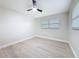 This bedroom is freshly painted and includes a ceiling fan and wood-look flooring at 8375 Burgundy N Dr, Pinellas Park, FL 33781