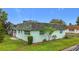 Cozy home featuring lush green lawn with side decorative planting and gray tile roof at 8375 Burgundy N Dr, Pinellas Park, FL 33781