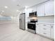 Well-lit kitchen with stainless steel appliances, white cabinets, and modern countertops, perfect for culinary enthusiasts at 8375 Burgundy N Dr, Pinellas Park, FL 33781