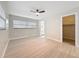 Bright main bedroom offering light wood-look floors, neutral walls, and an ensuite bathroom and closet at 8375 Burgundy N Dr, Pinellas Park, FL 33781
