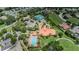Aerial view of a community clubhouse with a pool, tennis courts, and lush landscaping at 1012 Tuscany Dr, Trinity, FL 34655