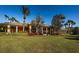 Elegant clubhouse exterior with lush landscaping, a red tile roof, and stately columns at 1012 Tuscany Dr, Trinity, FL 34655