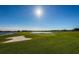 Picturesque golf course featuring a sand trap, lush green fairways, and a serene lake under a clear, sunny sky at 1012 Tuscany Dr, Trinity, FL 34655
