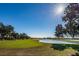 Expansive golf course view with players enjoying a sunny day and a serene lake at 1012 Tuscany Dr, Trinity, FL 34655