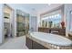 Main bathroom featuring a garden tub with granite surround, large vanity, and glass-enclosed shower at 1012 Tuscany Dr, Trinity, FL 34655