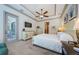 Bright main bedroom featuring tray ceiling, dresser, wall-mounted television, and private lanai access at 1012 Tuscany Dr, Trinity, FL 34655
